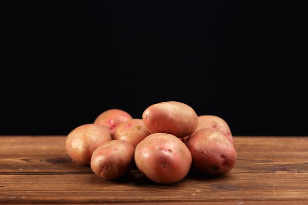 Stapel von den Kartoffeln, die auf hölzernen Brettern liegen