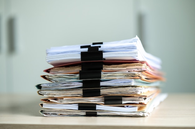 Stapel von Dokumenten mit Büroklammerordner auf einem Geschäftstisch in einem Geschäftsbüro.