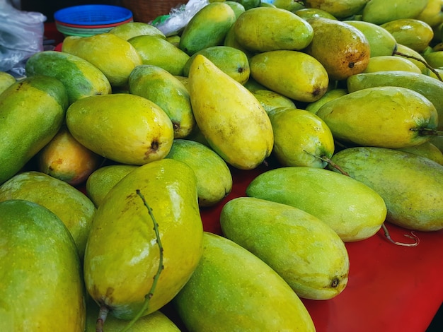 Stapel von frischen grünen reifen Mangos am Markt