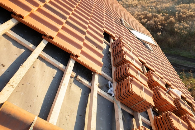 Stapel von gelben keramischen Dachziegeln zur Abdeckung von im Bau befindlichen Wohngebäudedächern