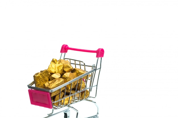 Stapel von Goldnuggets oder Golderz im Warenkorb oder in der Supermarktlaufkatze auf weißem Hintergrund