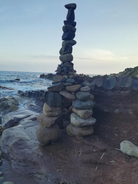 Stapel von Kieselsteinen am Strand gegen den Himmel