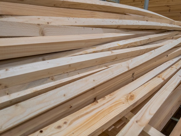 Stapel von langen Holzstäben mit quadratischem Querschnitt, leicht gebogen