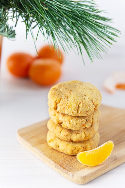 Foto stapel von mandarinenplätzchen mit einem fichtenzweig. zucker, gluten, laktosefrei.