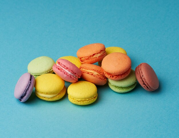 Stapel von mehrfarbigen runden gebackenen Macarons-Kuchen auf einem Blau