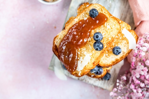 Stapel von süßen French Toasts mit Beeren-Karamell-Sauce und Kokosflocken Hausgemachte Brioche