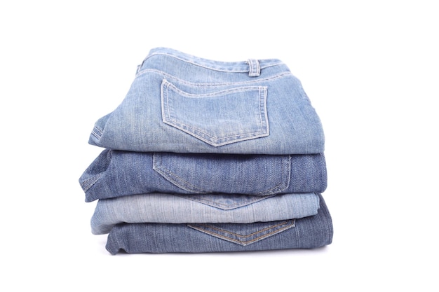 Stapel von verschiedenen Arten von Jeans auf weißem Hintergrund