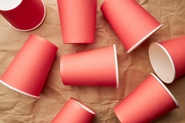 Foto stapel wegwerfbarer roter pappbecher auf papierhintergrund. umweltfreundliches konzept. schau von oben. hintergrund hintergrund