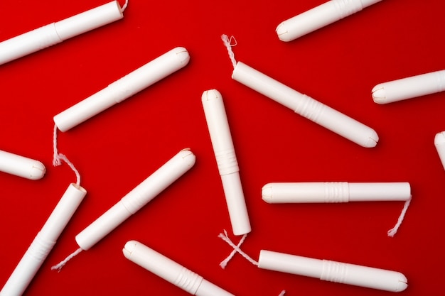 Stapel weiblicher Tampons auf rotem Hintergrund