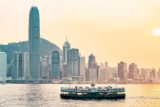 Star Ferry am Victoria Harbour und die Skyline von Hongkong bei Sonnenuntergang. Blick von Kowloon auf HK Island.