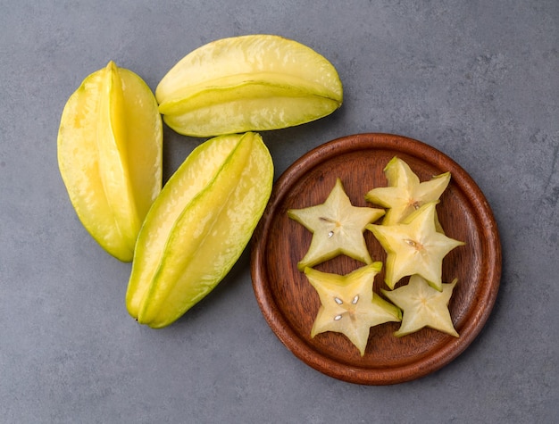 Starfruits mit Scheiben in einer Platte über Steinhintergrund