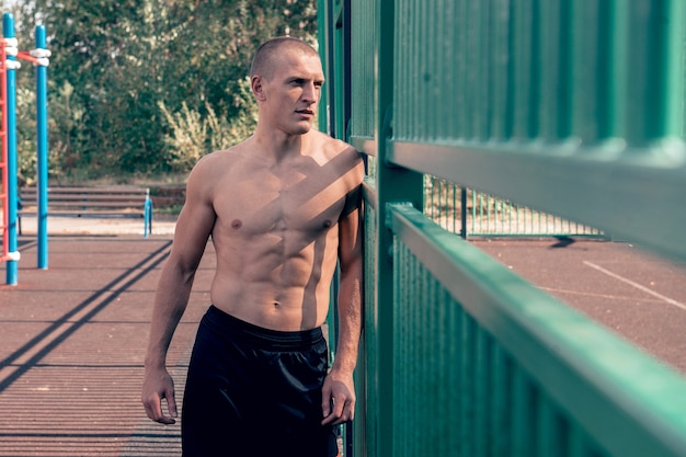 stark trainierter Mann Athlet posiert auf dem Sportplatz muskulöser starker Körper