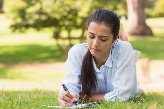 Starke Frau mit Buch und Stift im Park