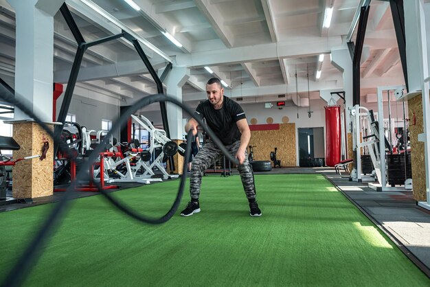 Starke junge Athleten tragen Sportbekleidung, die im Fitness-Studio Bodyweight-Building-Konzept trainiert