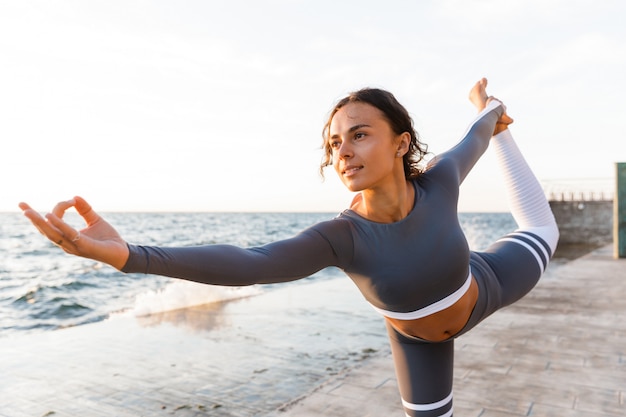 Starke junge Fitnessfrau, die sich streckt