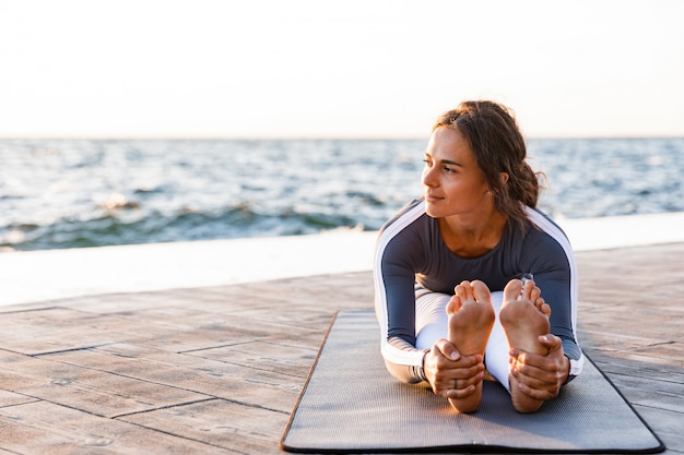 Starke junge Fitnessfrau, die sich streckt