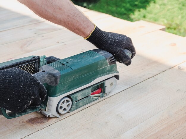 Starke Männerhände und eine Maschine zum Arbeiten mit Holz