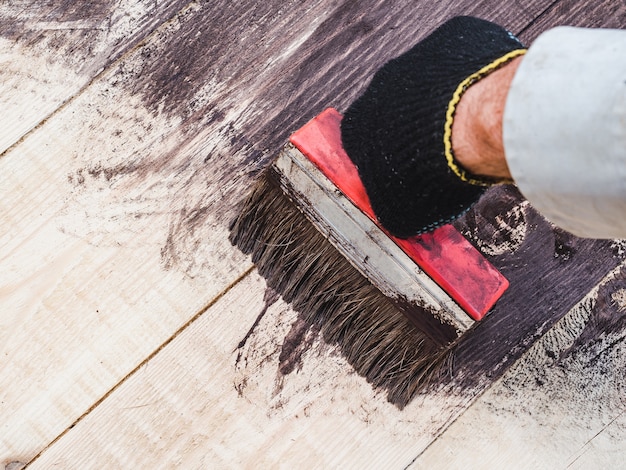 Starke männliche Hände, die hölzerne Bretter malen. Nahansicht