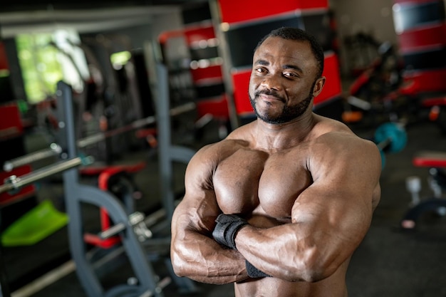 Starker athletischer Mann mit muskulösem Körper Nackter Torso-Muskel-Bodybuilder, der im Fitnessstudio posiert