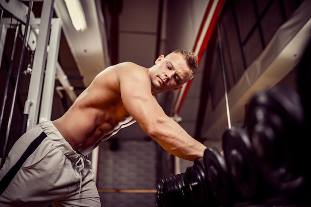 Starker Bodybuilder, der Schwergewichts- Übung für Rücken tut