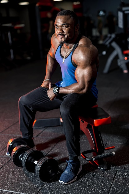 Starker gutaussehender Mann mit Muskeln, die im Fitnessstudio trainieren. Fitnesssportler, der Übungen macht