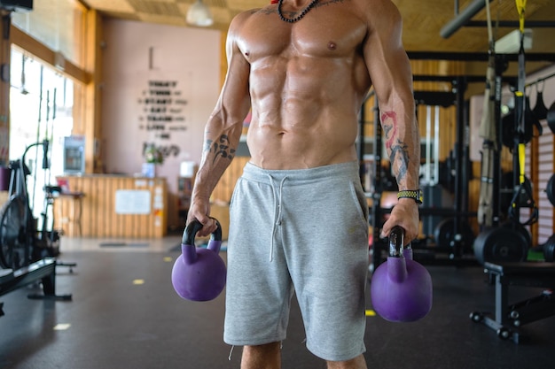 Starker Mann benutzt Kettlebells in einem Fitnessstudio