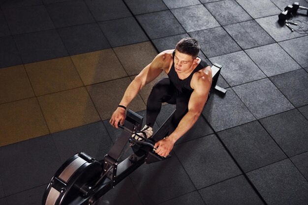 Starker Mann in sportlicher Kleidung hat einen Trainingstag im Fitnessstudio