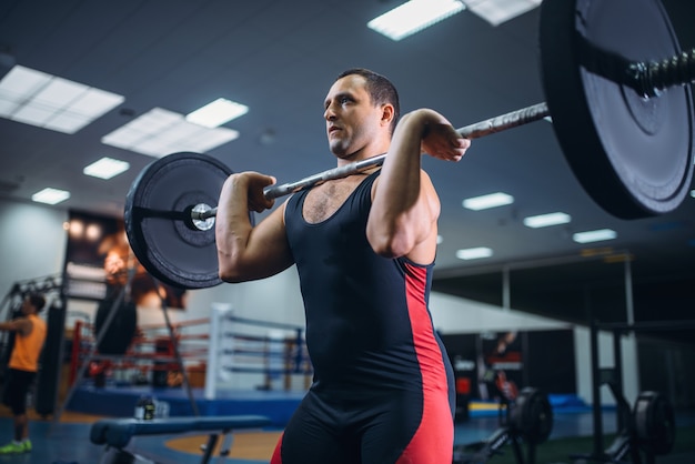 Starker Powerlifter beim Kreuzheben einer Langhantel im Fitnessstudio