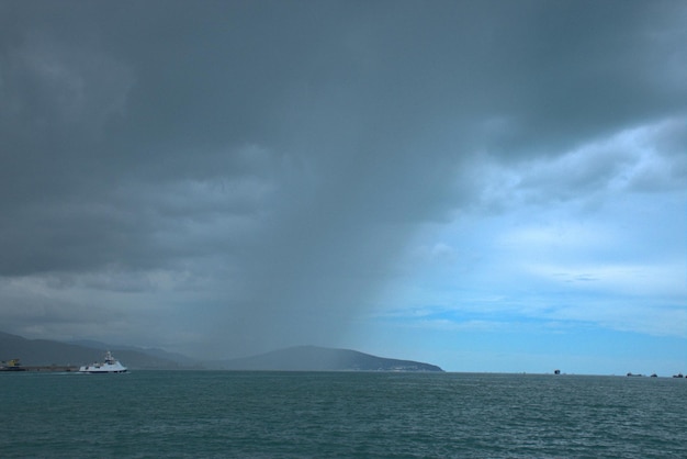 Starker Regen über dem Schwarzen Meer Dunkle Wolken mit einem Regenband am blauen Himmel