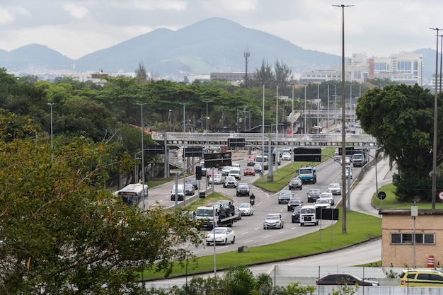 Starker Verkehr auf der Avenida Ayrton Senna im Viertel Barra da Tijuca auf der Westseite der Stadt Rio de Janeiro Bewölkter Tag Rio de Janeiro Brasilien August 2022