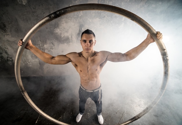 Starker Zirkusartist, der ein Cyr Wheel dreht