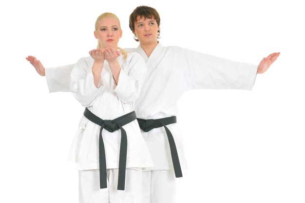 Starkes junges blondes Mädchen und der freche Karate-Typ trainieren in einem Kimono auf Weiß