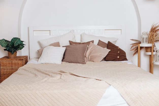 Startseite Schlafzimmer Nahaufnahme Pflanze Blumentopf in der Nähe des Bettes Zimmer natürliche Dekoration im Hausinneren niemand in der modernen Wohnung Bettwäsche Decke Dekor im minimalistischen Möbeldesign Dekoration im Boho-Stil