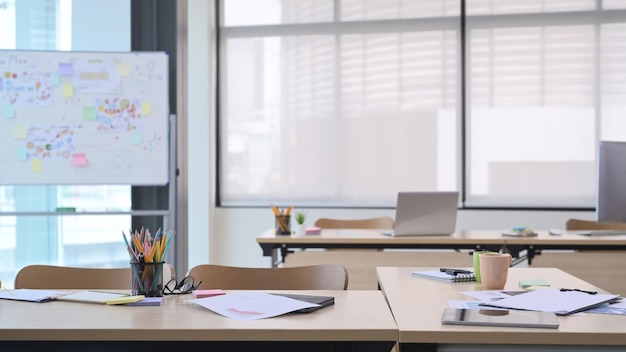 Startup-Business-Büro-Interieur mit Tischen, Stühlen und Laptop-Computer und Whiteboard