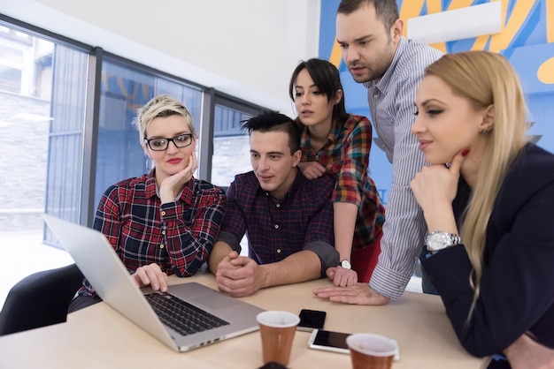 Startup-Business-Team bei Treffen in modernen, hellen Büroräumen, Brainstorming, Arbeiten an Laptop und Tablet-Computer