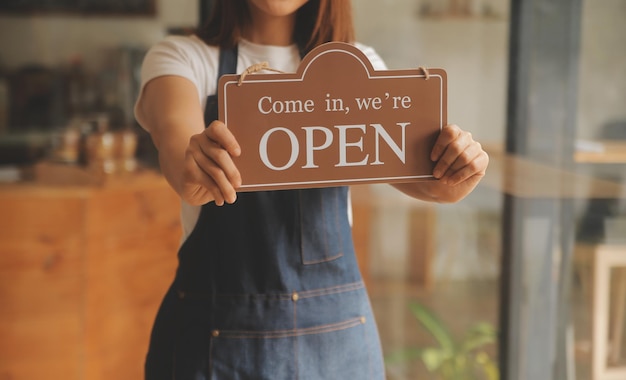 Foto startup exitoso propietario de una pequeña empresa sme chica de belleza con tablet smartphone en un restaurante de cafetería retrato de una mujer asiática bronceada barista propietaria de una cafetería pyme empresario vendedor concepto de negocio