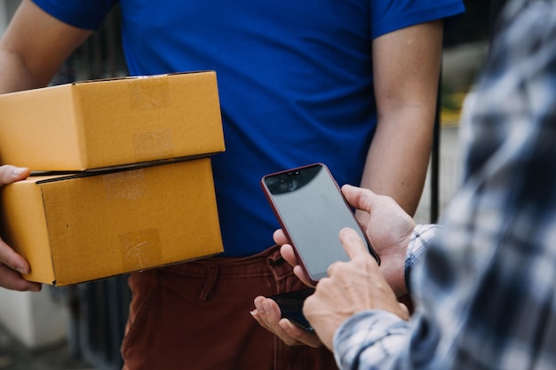 Startup-KMU-Kleinunternehmer einer freiberuflichen asiatischen Frau mit Schürze, die mit Laptop und Box Bestellungen online entgegennimmt und überprüft, um sich darauf vorzubereiten, KMU-Geschäftsideen online an Kunden zu verkaufen