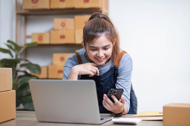 Foto startup pequeno empresário pme mulher asiática receber encomenda por telefone retrato jovem proprietário de pequena empresa asiática escritório em casa vender on-line entrega de marketing pme comércio eletrônico conceito de telemarketing