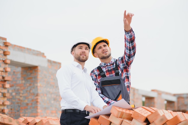 Statiker und Vorarbeiter besprechen Planarbeiten für die Baustelle im Freien