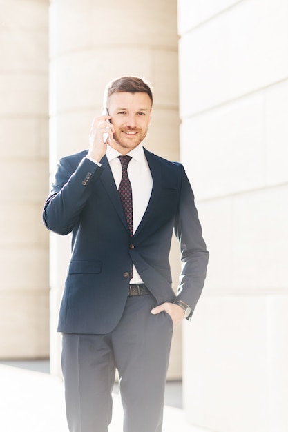 Stattlicher erfolgreicher männlicher Finanzdirektor löst Probleme über intelligentes Telefon