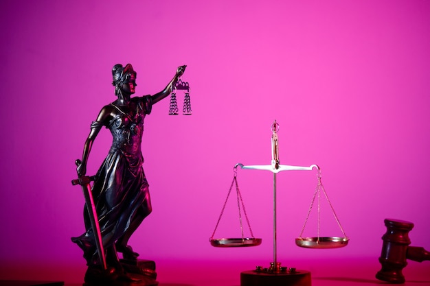 Statue von Lady Justice auf dem Tisch in lila Neon.