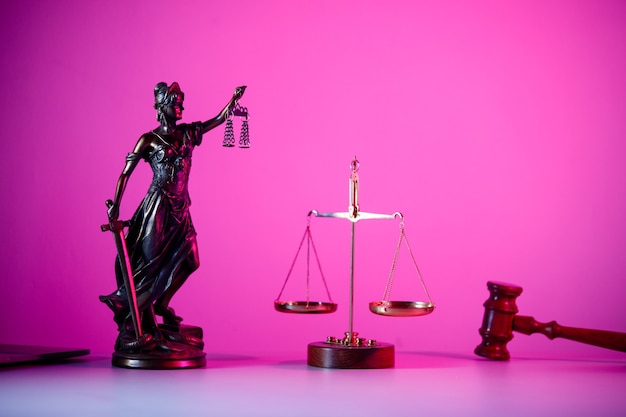 Statue von Lady Justice mit Schuppen in lila Neon. Symbol für Gerechtigkeit und Gesetz.