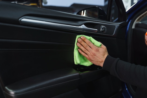 Foto staub im auto abwischen. autoreinigung. nasse autoreinigung