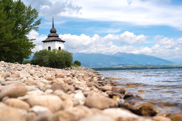 Stausee Liptovska Mara in der Slowakei. Alte Kirche in der Region Liptov mit Tatra-Hintergrund