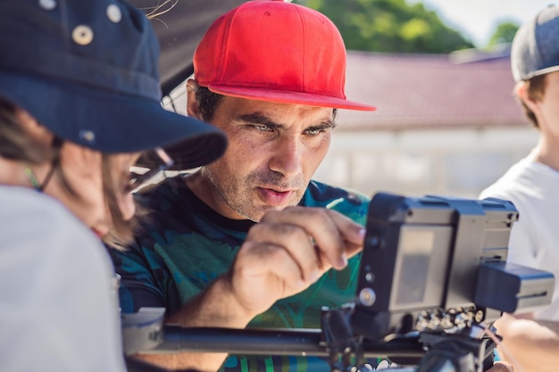 Steadicam-Operator und sein Assistent bereiten Kamera und 3-Achsen-Stabilisatorgimbal für einen Werbedreh vor