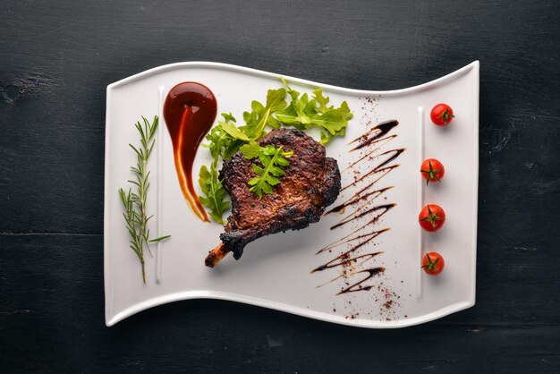 Steak auf einem Knochen mit Tomaten und Haselnuss Steak Fiorentino Auf einem hölzernen Hintergrund Freier Platz für Ihren Text Ansicht von oben