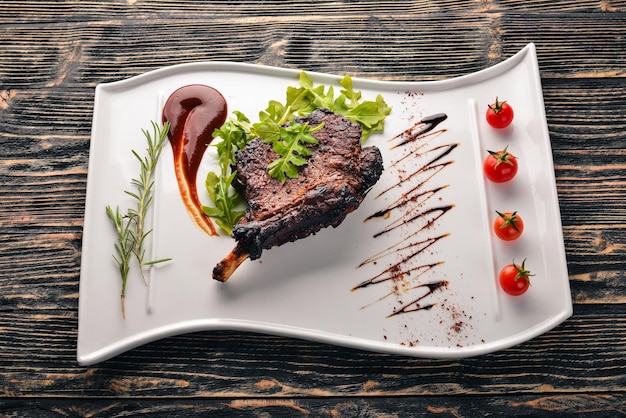 Steak auf einem Knochen mit Tomaten und Haselnuss Steak Fiorentino Auf einem hölzernen Hintergrund Freier Platz für Ihren Text Ansicht von oben