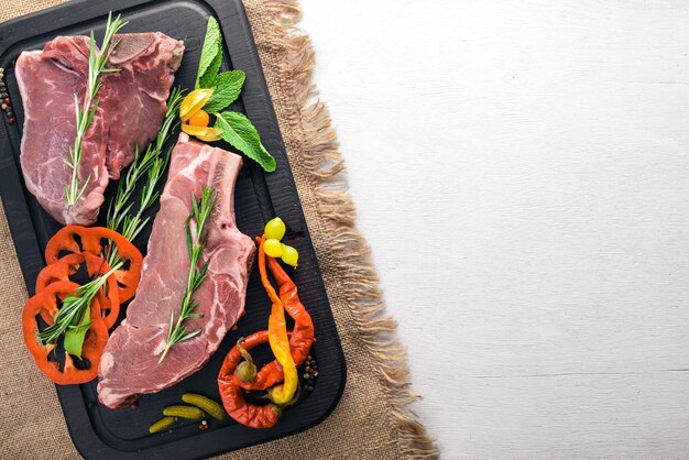 Steak rohes Fleisch und Gewürze auf Holzbrett Draufsicht Freier Speicherplatz