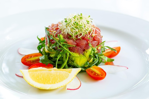 Foto steak tartare, teller mit leckerem rindertatar auf weißem hintergrund