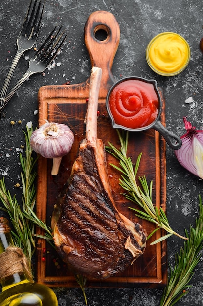 Steak Tomahawk am Knochen gegrillt mit Rosmarin und Gewürzen Draufsicht Freier Platz für Ihren Text